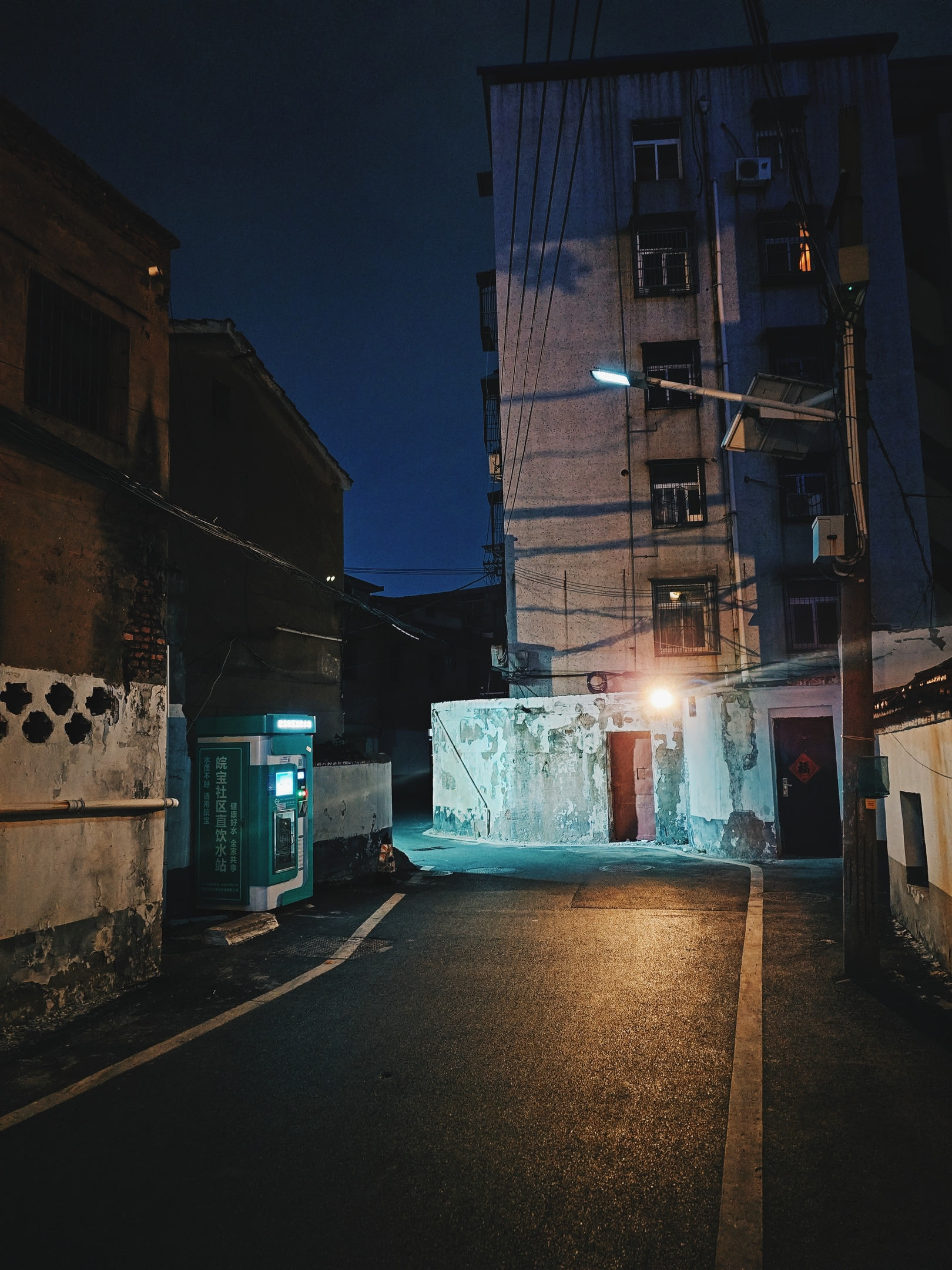 Residential side-street at night, old apartment building.