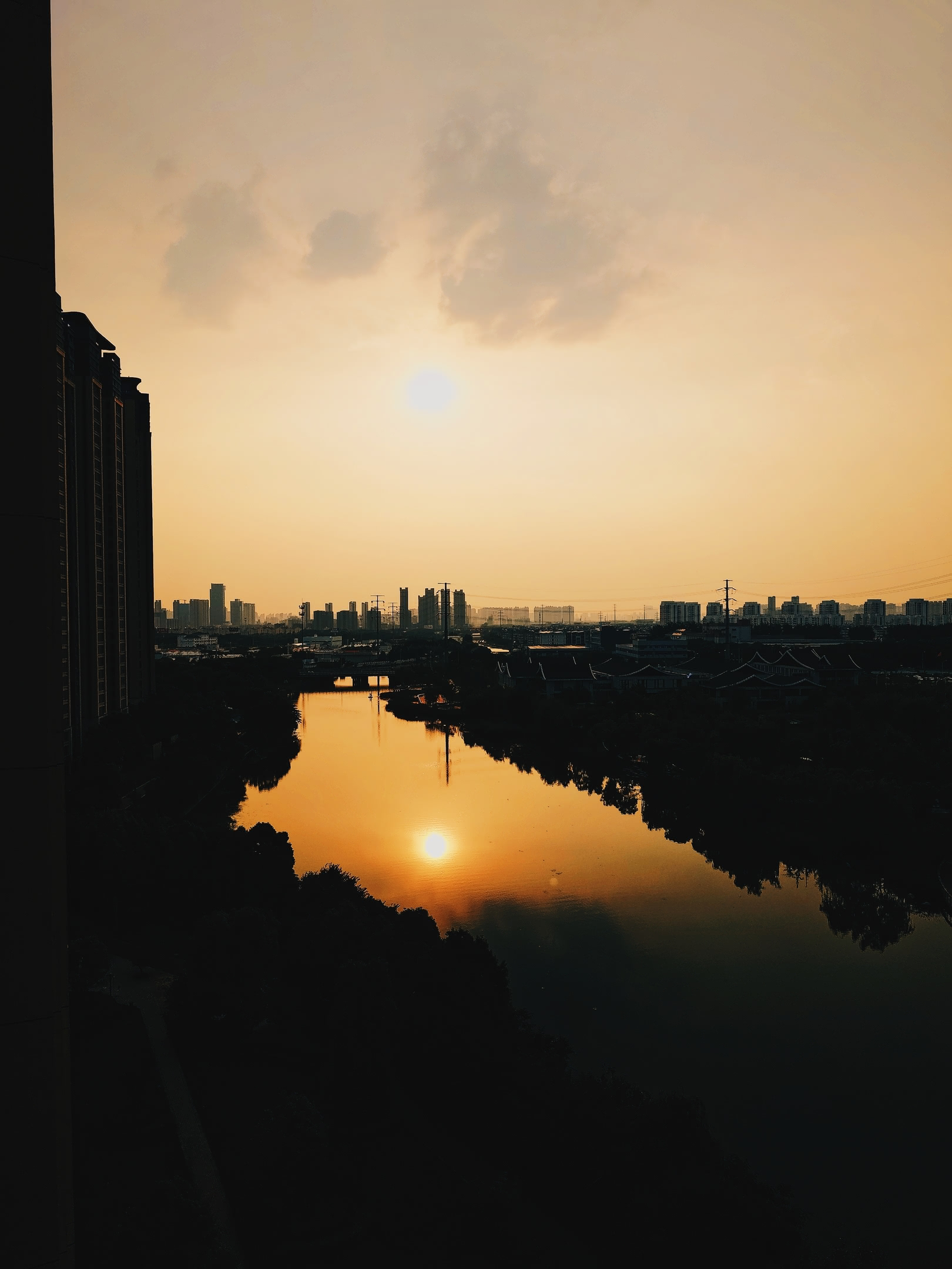 Golden evening sun descending over river.