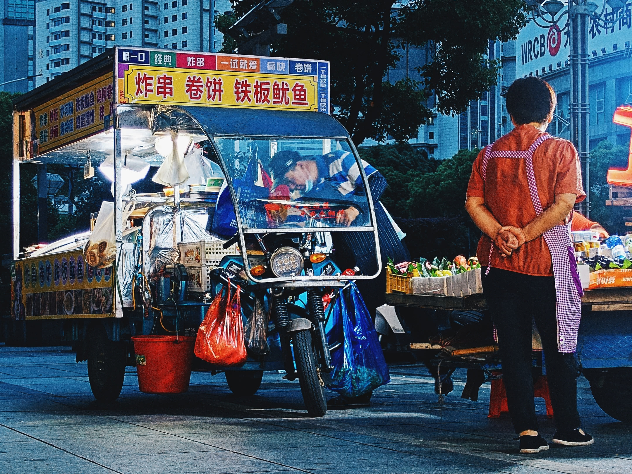 Street vendors at dawn outside a city bar.