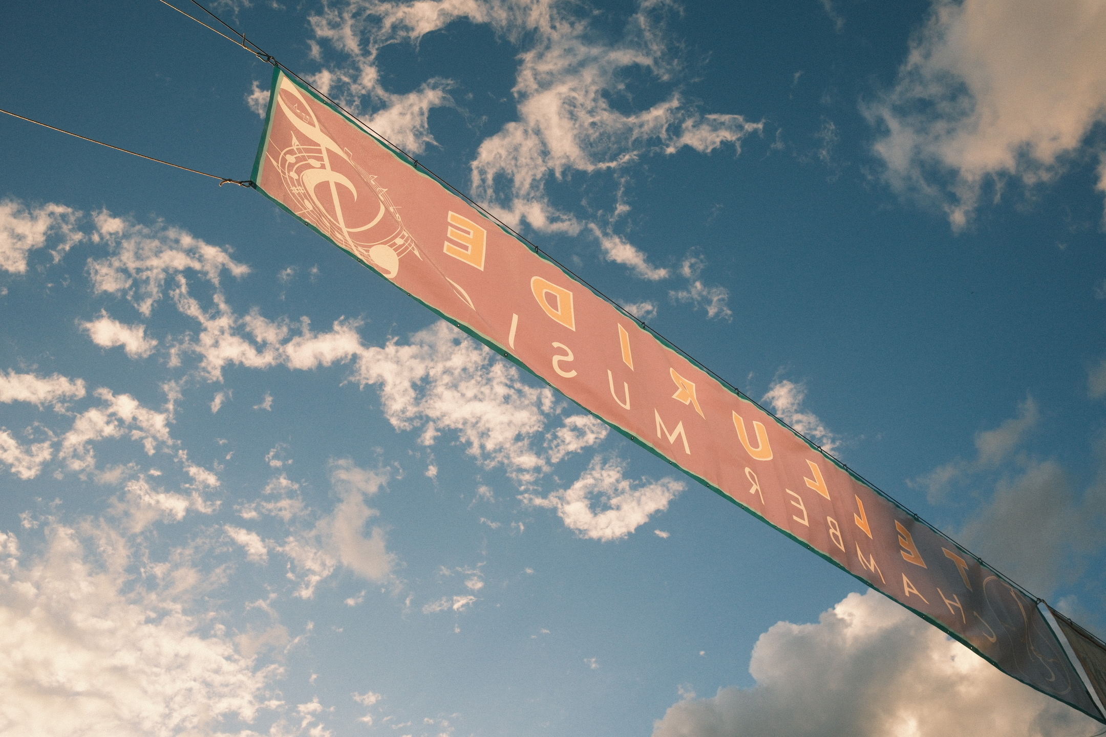 Banner against blue afternoon sky, illuminated with goden hour light.